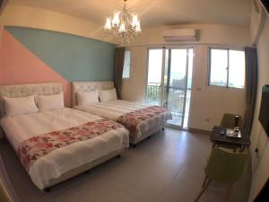 una camera d'albergo con due letti e un lampadario a braccio di Mi Hai B&B a Ji'an