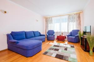 a living room with a blue couch and two chairs at Centr Kvartir 25 in Minsk