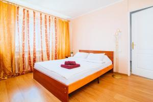 a bedroom with a bed and a large window at Centr Kvartir 25 in Minsk