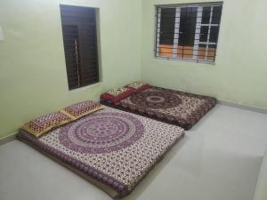 two mats sitting on the floor in a room at Xavier Guest House in Chennai