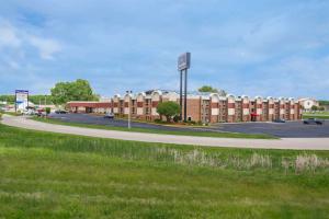 a building with a street sign next to a road at AmericInn by Wyndham Janesville in Janesville