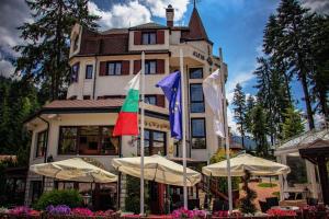 a large building with flags in front of it at Alpin Borovets, Алпин Боровец in Borovets