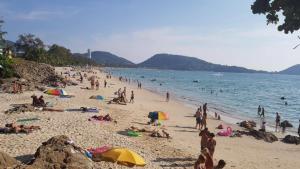 a group of people on a beach in the water at Baan Thai Beach Side Residence in Patong Beach