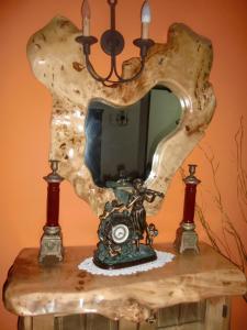 a mirror on top of a table with a clock at O Lar da Avoa in Cambados