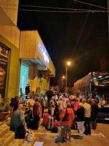 a crowd of people standing outside of a store at night at Hotel Makona in Tbilisi City