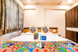 a bedroom with two beds with a colorful bedspread at FabHotel Imperio - Nr Baner Hill in Pune