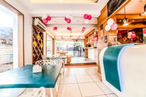 ein Esszimmer mit einem blauen Tisch und rosa Ballons in der Unterkunft FabHotel Imperio Baner in Pune