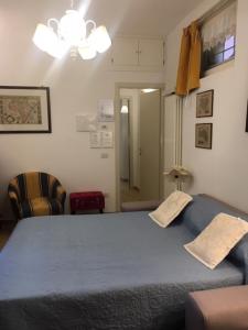 a bedroom with a blue bed and a chair at IL VICOLETTO Appartamento in Cesena