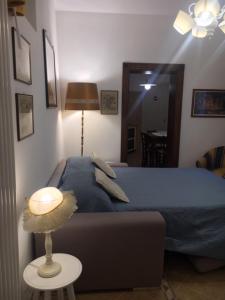 a bedroom with a blue bed and a table with a lamp at IL VICOLETTO Appartamento in Cesena