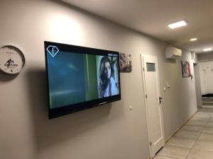 uma televisão de ecrã plano pendurada numa parede em Klimatyzowany Apartament Paris em Kielce