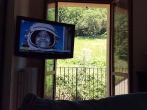 een televisie met een foto van een jongen in een ruimtepak op een raam bij VISTA PANORAMICA SULLE TERME DI SATURNIA in Poggio Murella