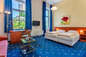 a hotel room with two beds and a desk at Hotel Schloss Hornberg in Hornberg