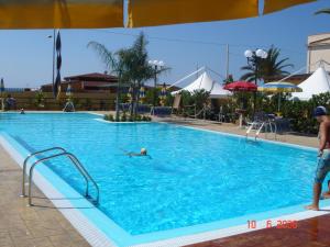 a person swimming in a large swimming pool at Case Vacanze Ancora in Porto Empedocle