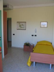 ein Schlafzimmer mit einem Bett mit einer gelben Decke in der Unterkunft Locanda dei 4 in Narni