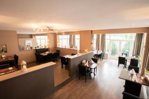 a restaurant with tables and chairs and a bar at De Vier Linden in Vierlingsbeek