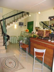 a restaurant with a bar with chairs and stairs at Locanda dei 4 in Narni