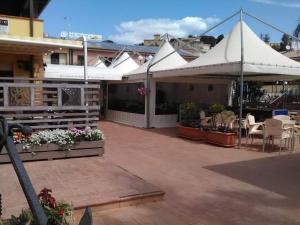 a patio with white umbrellas and tables and chairs at Case Vacanze Ancora in Porto Empedocle