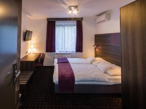 a hotel room with a large bed and a window at Log In Rooms in Zagreb