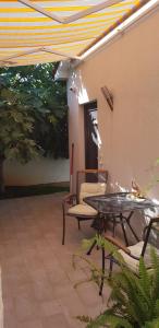 a patio with a table and chairs and an umbrella at Apartmani Val in Pula