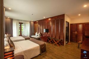 a hotel room with two beds and a television at Cottage Village in Phu Quoc +54 photos