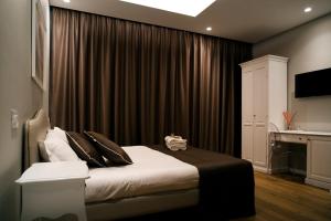 - une chambre avec un lit doté de rideaux noirs et un bureau dans l'établissement San Marco Antico Relais - B&B, à Bitonto