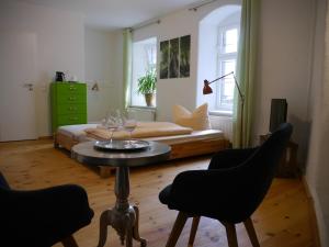 マイセンにあるStadtvilla Rosengasse 7のテーブル、椅子2脚、ベッド1台が備わる客室です。