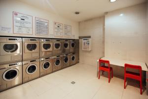 uma lavandaria com uma fila de máquinas de lavar e secar roupa em CM Antas Studios no Porto