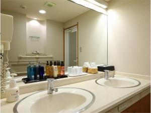 un bagno con due lavandini e un grande specchio di Yorozuya a Yamanouchi