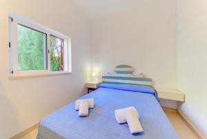 a bedroom with a blue bed with two towels on it at Beach Villa Pins by Sealand Villas in Cala de Sant Vicent +16 photos