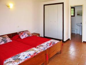 a bedroom with a bed with red sheets and a bathroom at Résidence Mari di Soli in Porto-Vecchio