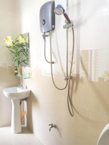 a shower in a bathroom with a toilet and a sink at Dream Flower Homestay in Hoi An