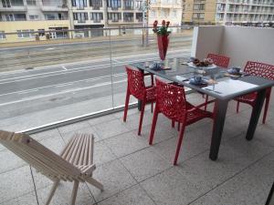 d'une table et de chaises sur un balcon avec vue sur la rue. dans l'établissement Osea Oostende, à Ostende