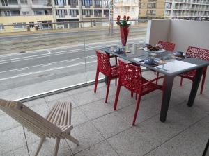 a table and chairs on a balcony with a view of a street at Osea Oostende in Ostend