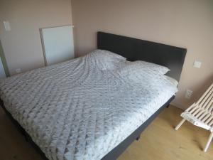 - un lit avec une couette blanche dans une chambre dans l'établissement Osea Oostende, à Ostende