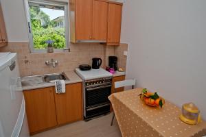 a small kitchen with a table with a bowl of fruit at Skourtis Apartments in Eleonas