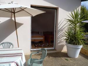 eine Terrasse mit einem Tisch, einem Stuhl und einem Sonnenschirm in der Unterkunft iguski in Boucau