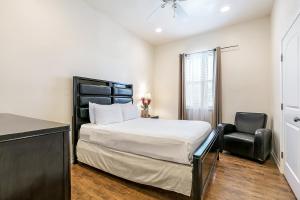 1 dormitorio con 1 cama y 1 silla negra en Inviting 3BR Condo steps from St Charles Ave, en Nueva Orleans