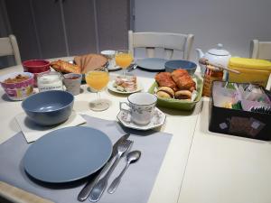 una mesa con platos y vasos de zumo de naranja y comida en chez Nathalie et Etienne, en Saillans