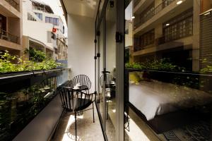 - Balcón con 2 sillas y 1 cama en Chez Mimosa Petite - Free Laundry, en Ho Chi Minh