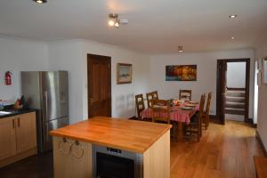 a kitchen and dining room with a table and a dining room at Diubaig House in Edinbane