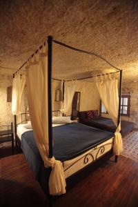 a bedroom with a canopy bed in a room at ROCA CAPPADOCIA in Ürgüp