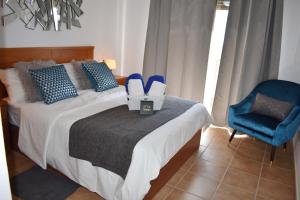 a bedroom with a bed with a blue chair and shoes at VILLA MOLEIRO- LA TEJITA in La Tejita