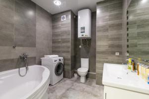 a bathroom with a toilet and a washing machine in it at Lux near Most City, river view, center new tower in Dnipro