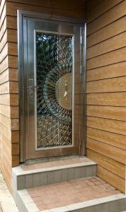 a glass door with a metal spiral on the side of a house at Cozy House in Rose Hill