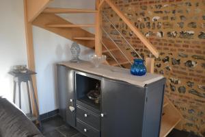 a living room with a staircase and a metal cabinet at Le Clos Masure in Doudeville