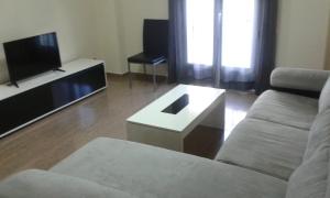 ein Wohnzimmer mit einem Sofa und einem TV in der Unterkunft VFT LA PAZ in Baeza
