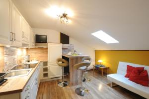 a kitchen with a sink and a couch in a room at Gstattlhof Mountain Lodge in Braies