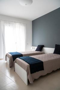 two beds in a white room with at CASA VITTORIA in Gravina in Puglia