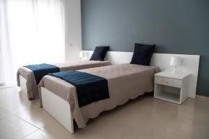 a bedroom with two beds and a night stand at CASA VITTORIA in Gravina in Puglia
