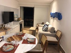 a living room with a table and a couch at La Fleur Polinesia Residence & Resort in Porto De Galinhas